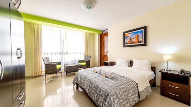 A hotel room with a bed, a desk, a chair, a nightstand, and a picture on the wall. - Hostal Florida (Chiclayo)