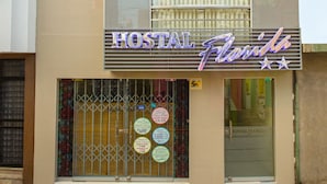 A building with a sign reading "HOSTAL Florida" and a window with a metal gate. - Hostal Florida (Chiclayo)