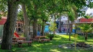 Un parc équipé de tables de pique-nique, d’une aire de jeux et d’un bâtiment orné de peintures murales colorées.