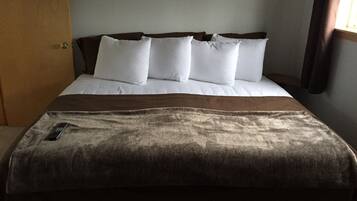 A bed with white bedding and a brown throw blanket.