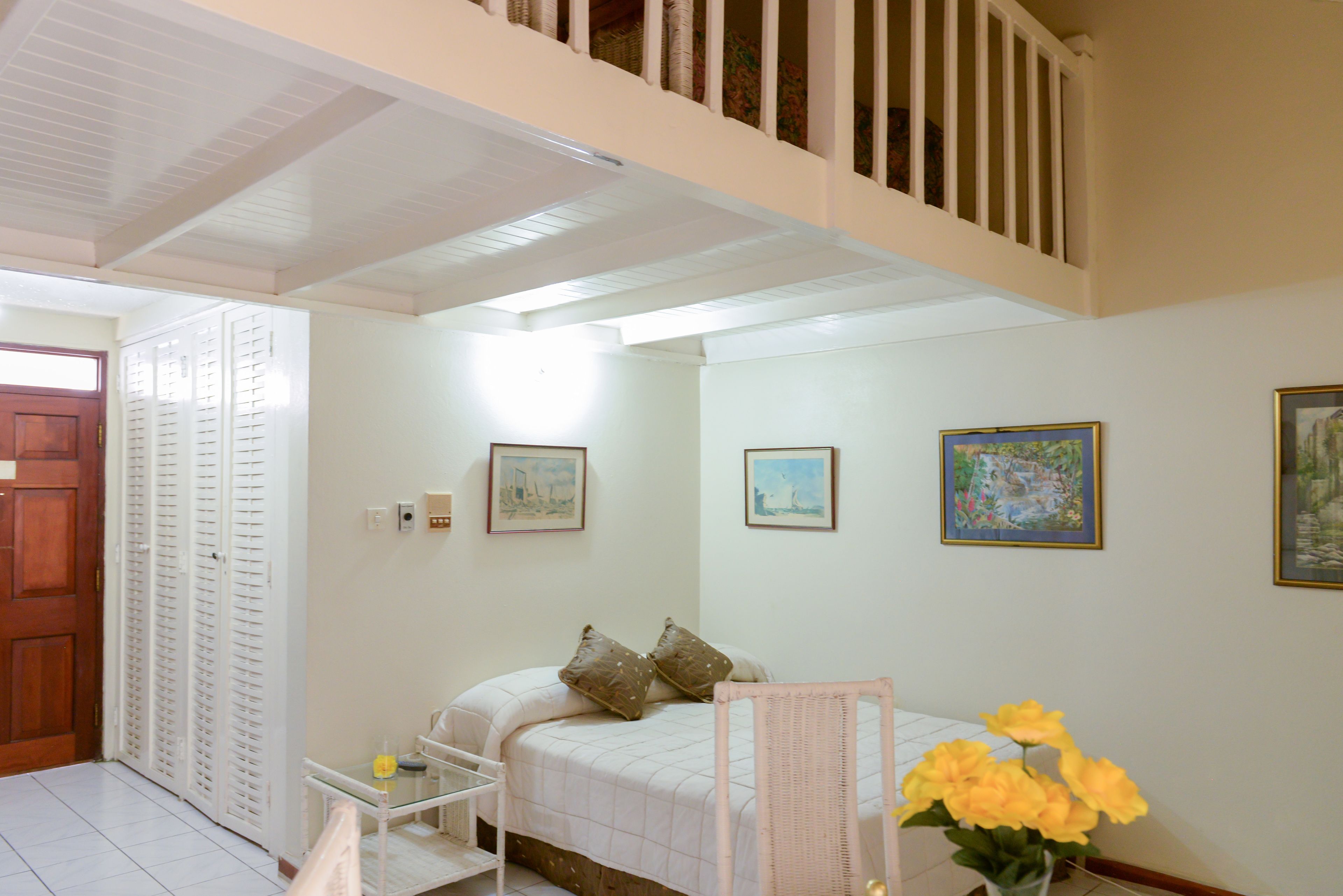 A bedroom with a bed, a chair, a small table, and a window.