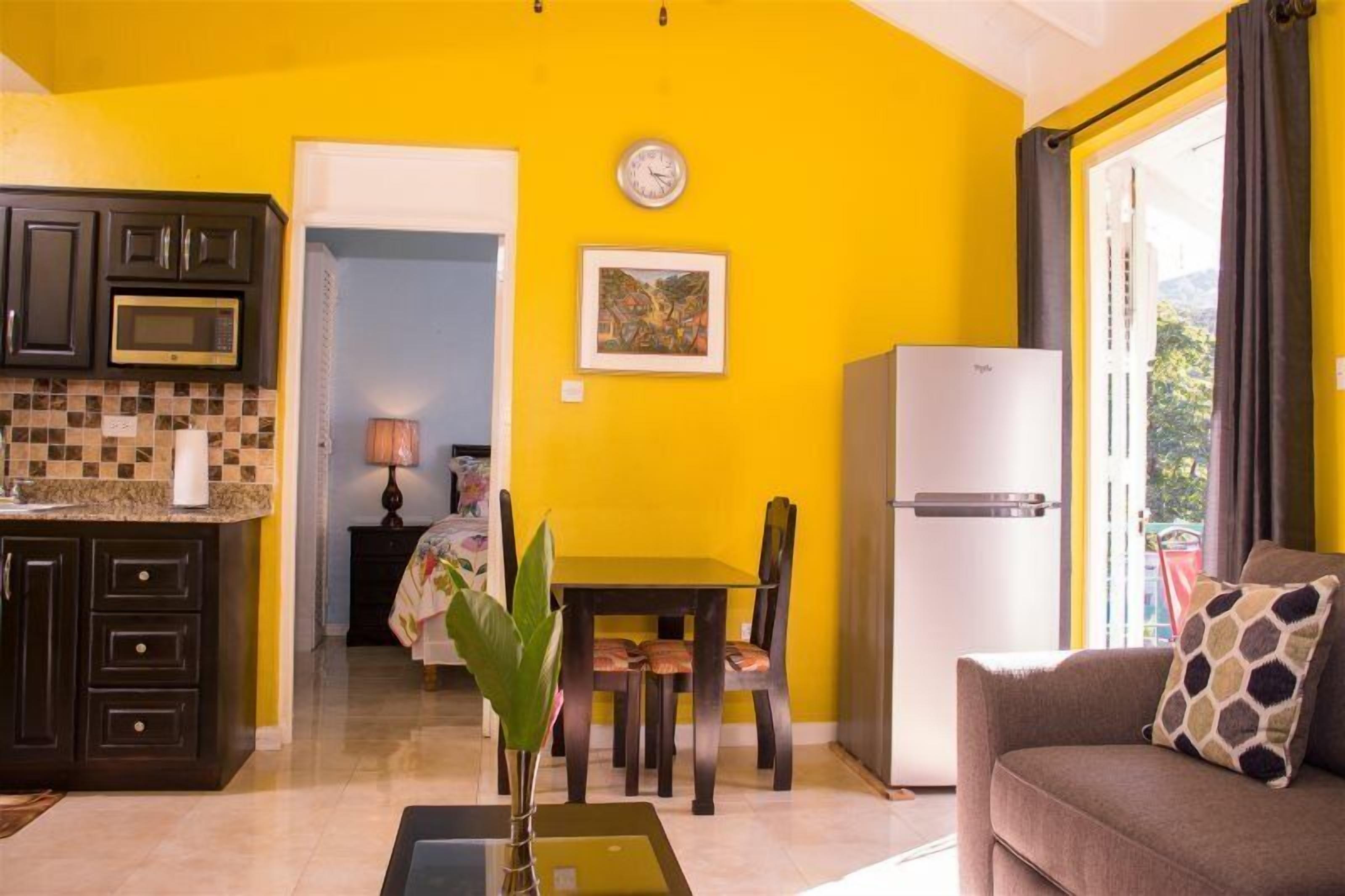 Un espace de vie compact comprenant une cuisine, un coin repas et un coin salon.