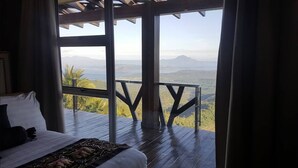 Un dormitorio con un ventanal grande que da a un paisaje montañoso.