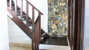 A wooden staircase with a stone wall at the bottom. - Seasta Beach Resort (Baler)