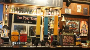A bar with a menu board, various bottles, and a sign for 'Special Pork BBQ'. - Seasta Beach Resort (Baler)