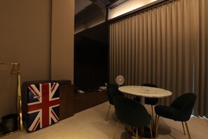 A room with a round table, black chairs, a small fan, and a wall with a Union Jack flag. - Hotel Yeogiuhtte Daegu Station (Daegu)