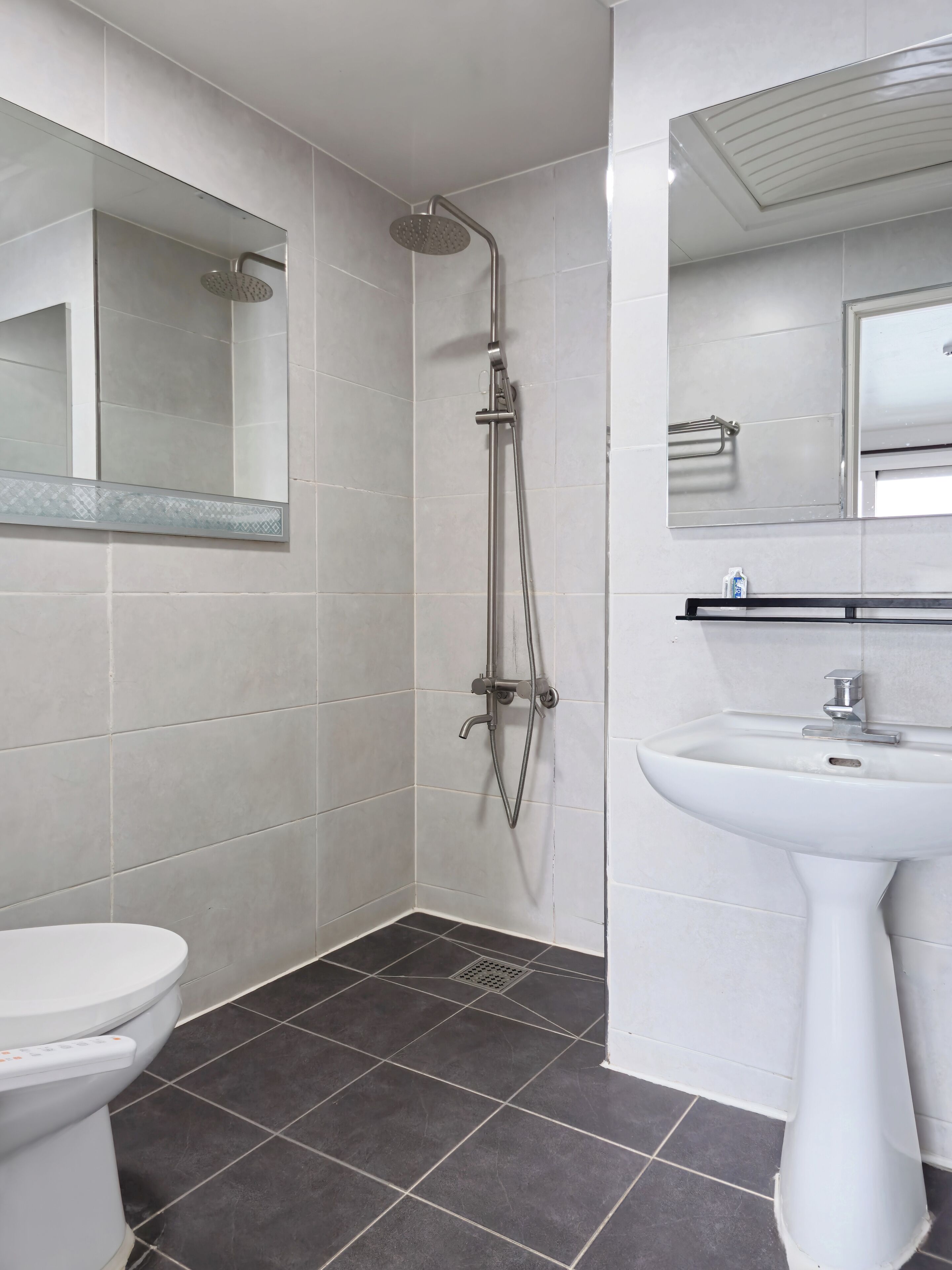 A modern bathroom with a shower, toilet, and sink.