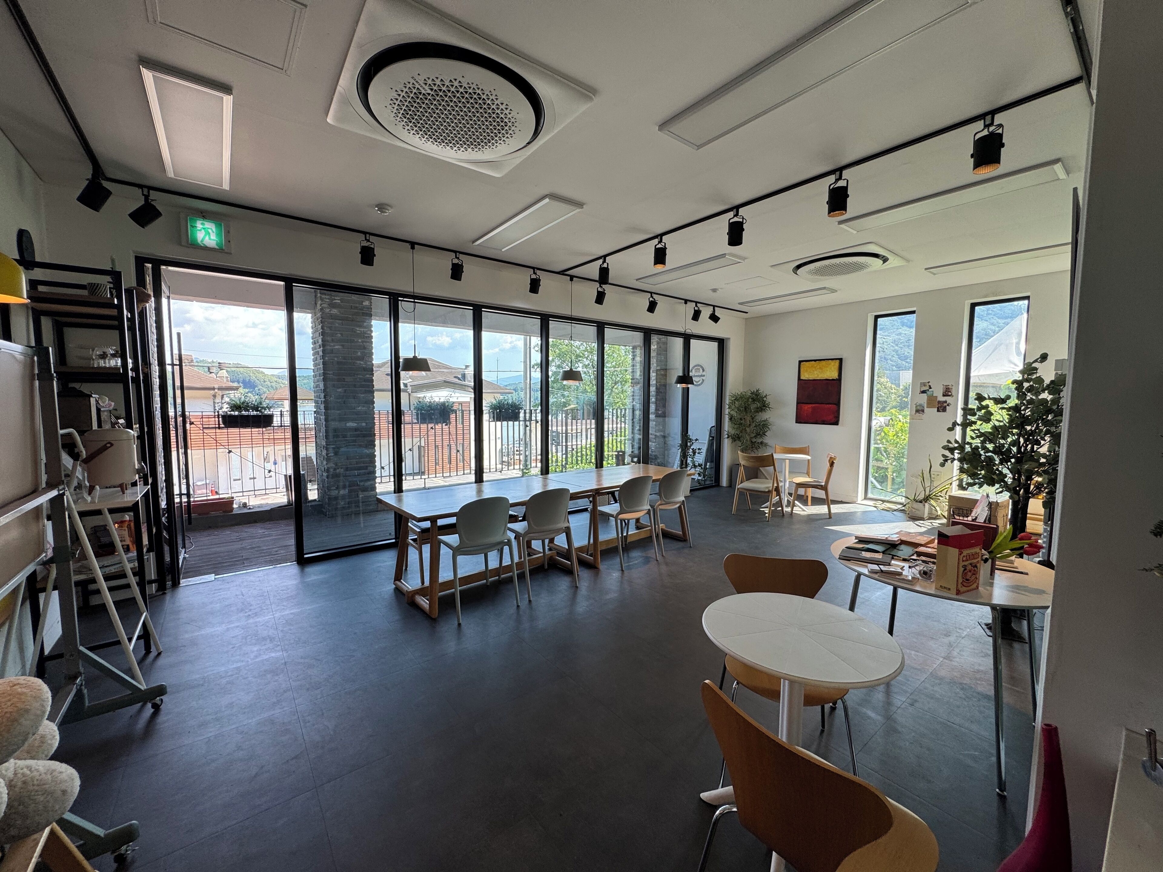 A spacious room with large windows, a conference table, and several chairs.