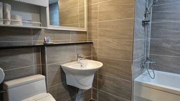 A modern bathroom with a toilet, sink, and shower.