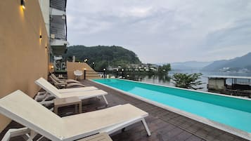 室外游泳池,開放時間為 12:00 至 19:30,提供日光浴躺椅