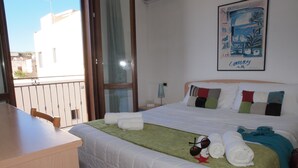 Une chambre d’hôtel avec un lit, un bureau et un balcon.