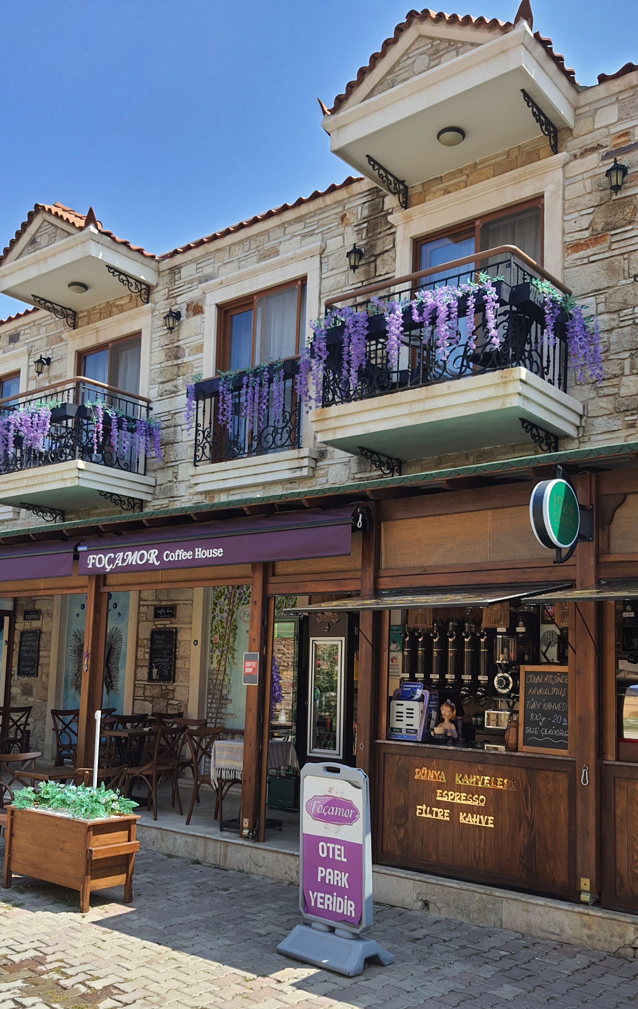 A two-story building with a coffee house named "Focamor Coffee House" on the ground floor. There is a sign indicating "Hotel Park Yeridir" and a menu board for coffee and espresso.