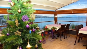 Comedor con un árbol de Navidad, piso de madera y vista a un cuerpo de agua.