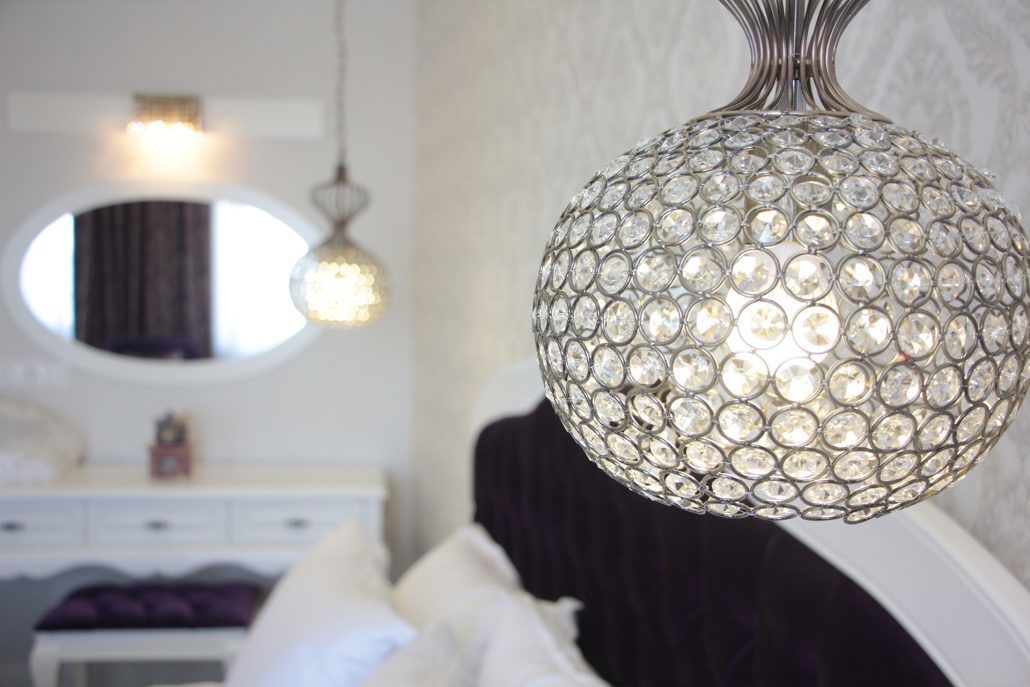 A chandelier with a spherical design and multiple clear crystals.