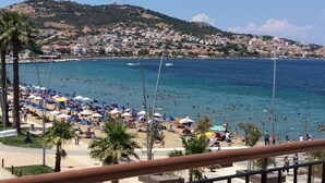 Una playa con sombrillas y gente nadando.