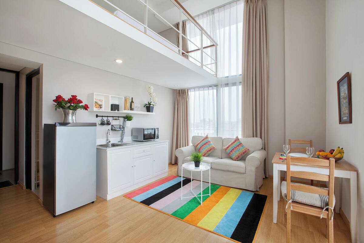A modern apartment with a kitchen, living area, and dining space.