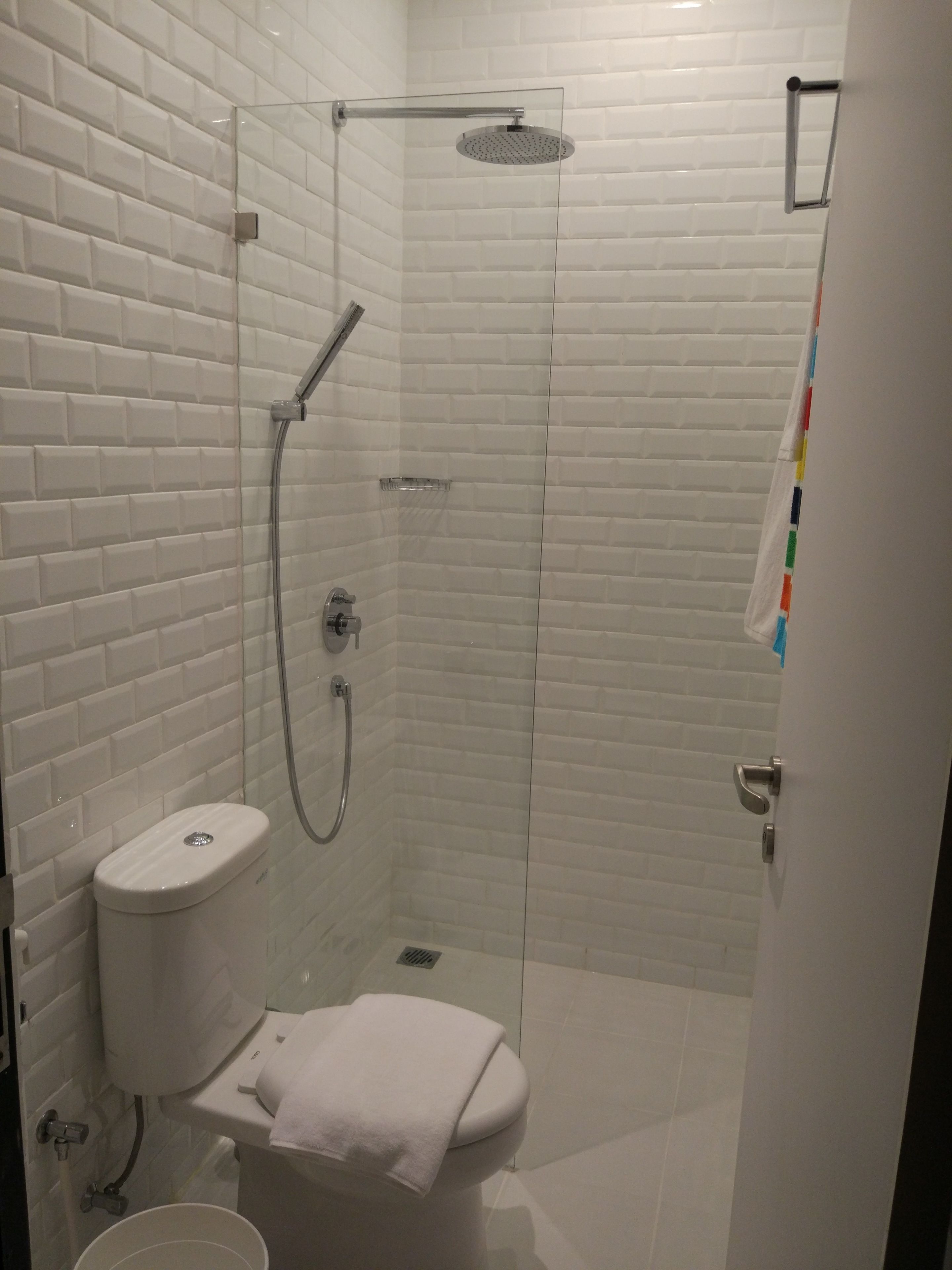 Un baño moderno con ducha de vidrio, inodoro y lavabo.