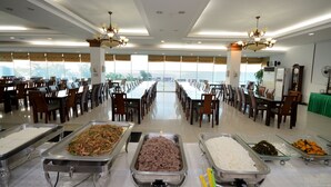 A spacious dining hall with multiple tables and chairs, arranged in rows, and buffet stations with various food items. - Daea Ulleung Resort (Ulleung)