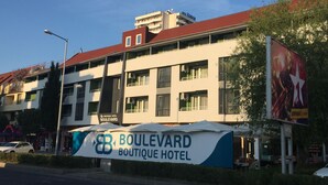 Un hôtel à plusieurs étages, doté de balcons et de climatiseurs.