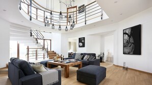 Un vaste espace de vie agrémenté d’un escalier en colimaçon, d’une table basse en bois et de meubles modernes.