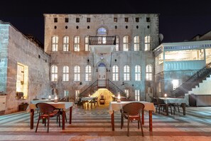 Un edificio histórico con patio de comidas, paredes de piedra y ventanas arqueadas.