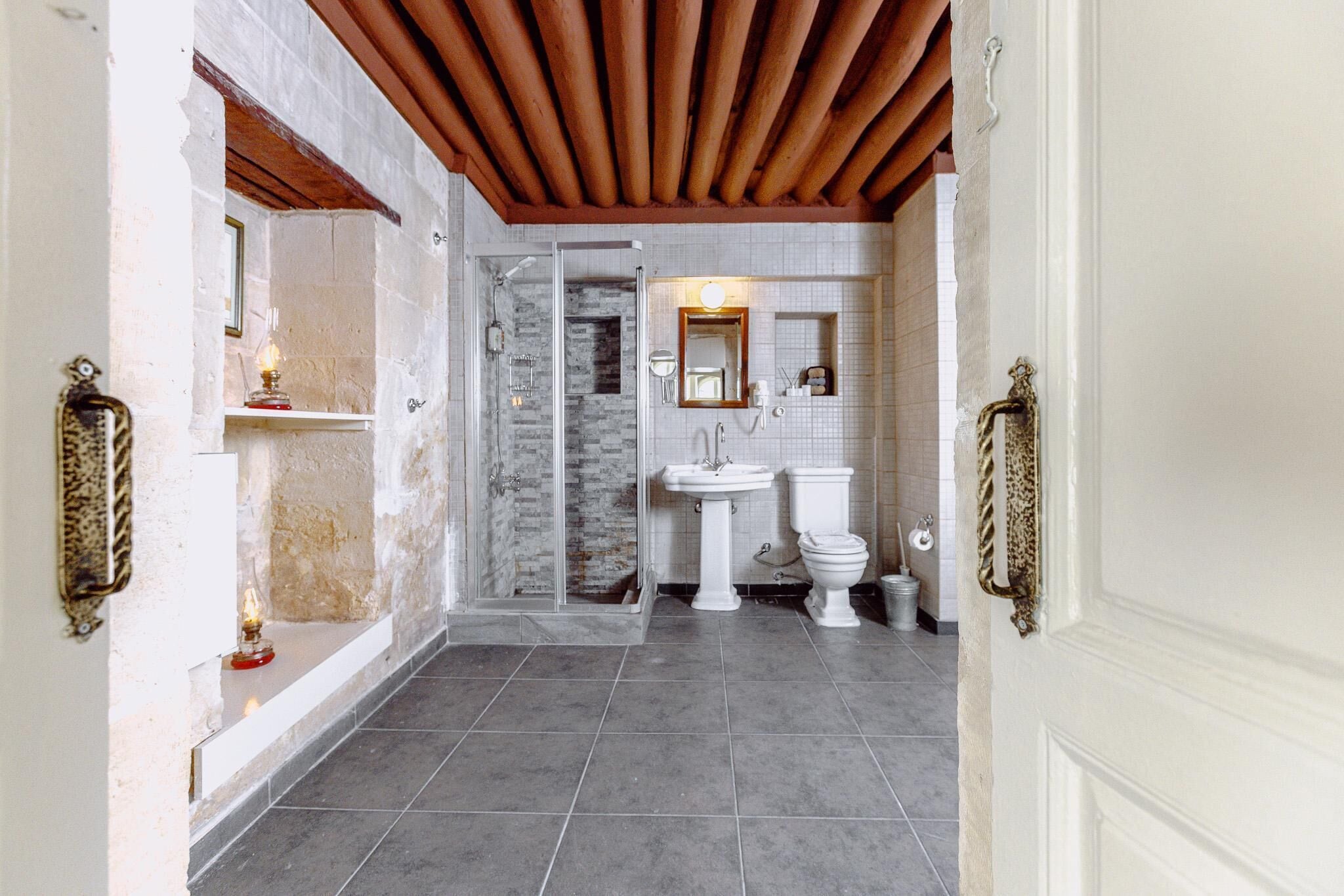 Een badkamer met een douche, wastafel en toilet.