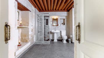 Een badkamer met een douche, wastafel en toilet.