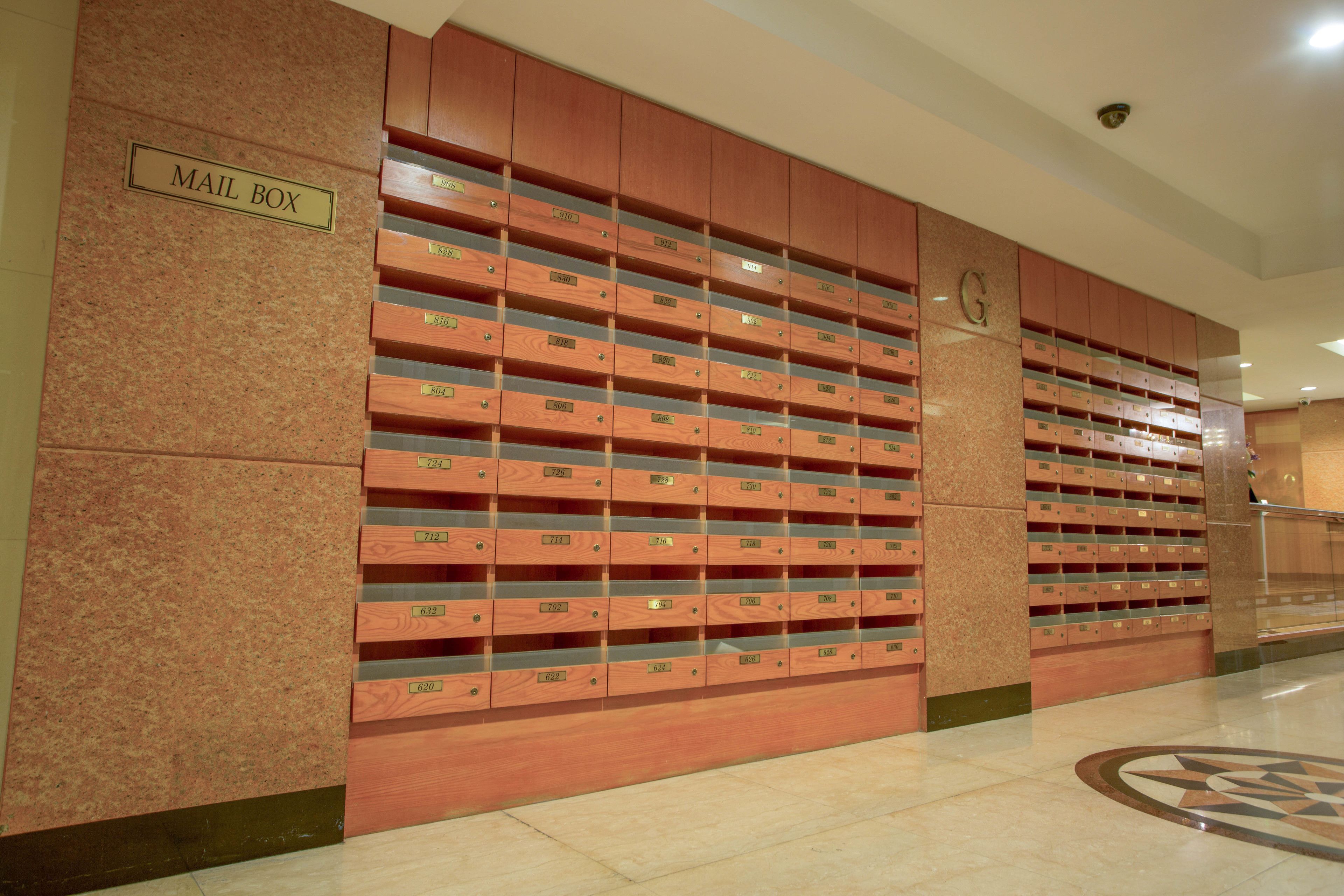 A mail room with wooden lockers and a sign labeled "MAIL BOX".
