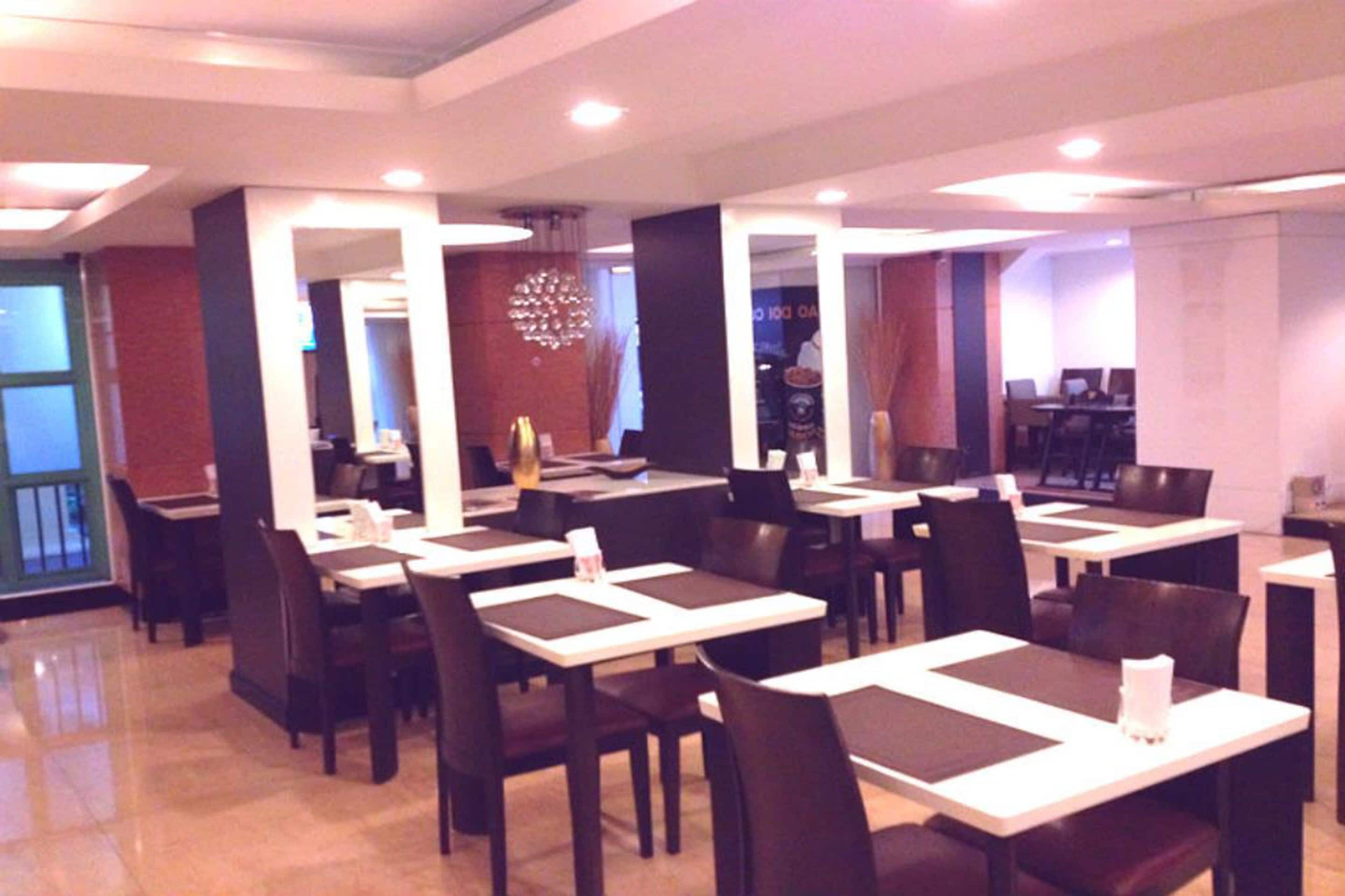 Un ristorante con diversi tavoli e sedie, un lampadario e vista sulla sala da pranzo.