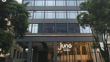 Un hotel moderno con fachada de vidrio y una entrada destacada.