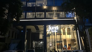 A modern hotel building with multiple floors, large glass windows, and illuminated exterior lighting. - Juno Tanah Abang Jakarta (Jakarta)