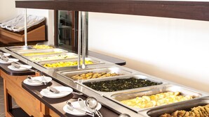 A buffet with various food options, including fruits, vegetables, and meats, arranged on a long table with serving utensils and plates. - Festa Gardenia Hills (Sunny Beach)
