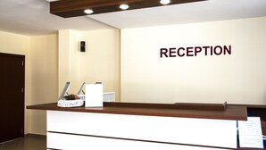 A reception desk with a sign that reads "RECEPTION" on the wall behind it. - Festa Gardenia Hills (Sunny Beach)