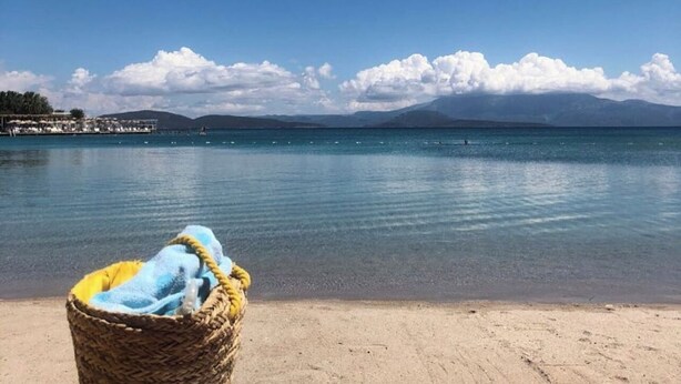 A beach with a clear sky, calm water, and a distant mountain range. - Cilek Butik Otel (Cesme)