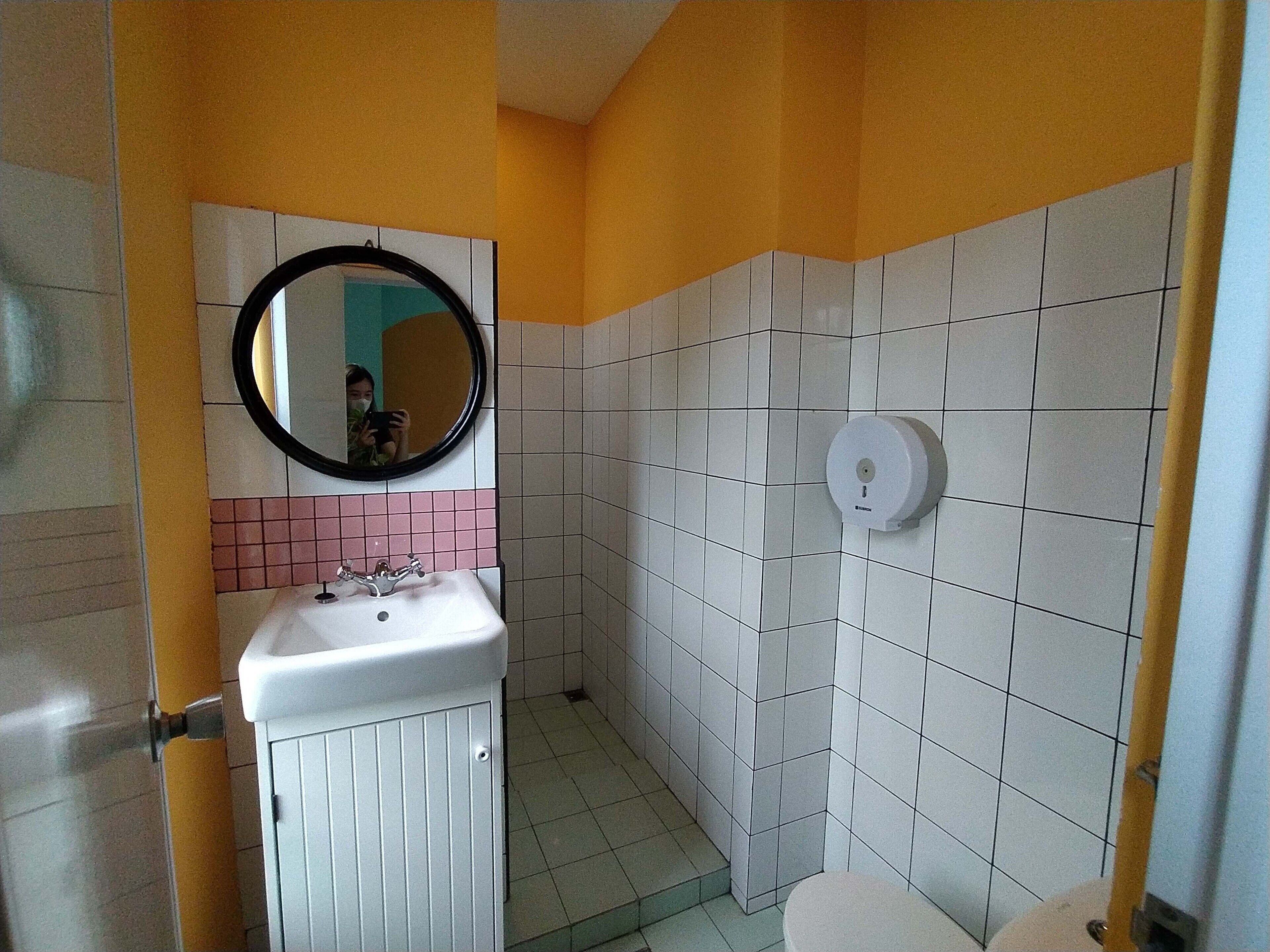 Une petite salle de bain avec un lavabo blanc, un miroir et des toilettes.