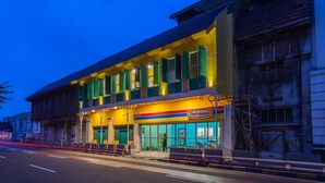A building with a storefront, a sign for 'Indomaret', and a street in the foreground. - Wonderloft Hostel Kota Tua (Jakarta)