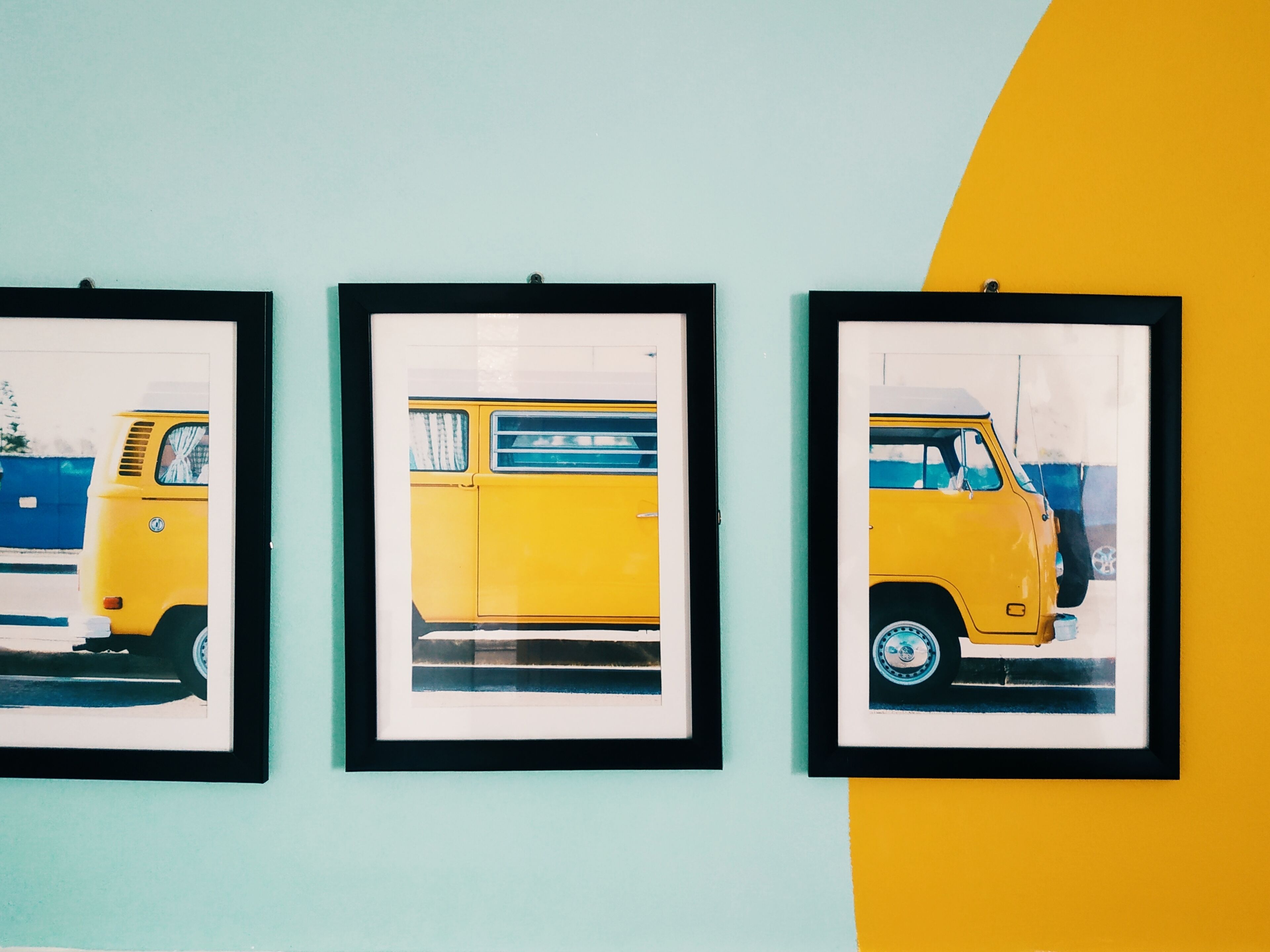 Three framed pictures of a yellow van on a wall.