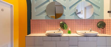 Un baño con dos lavamanos, un espejo y una planta.