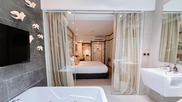Une salle de bain moderne dotée d’une grande baignoire, d’un meuble-lavabo avec miroir et d’un espace douche.