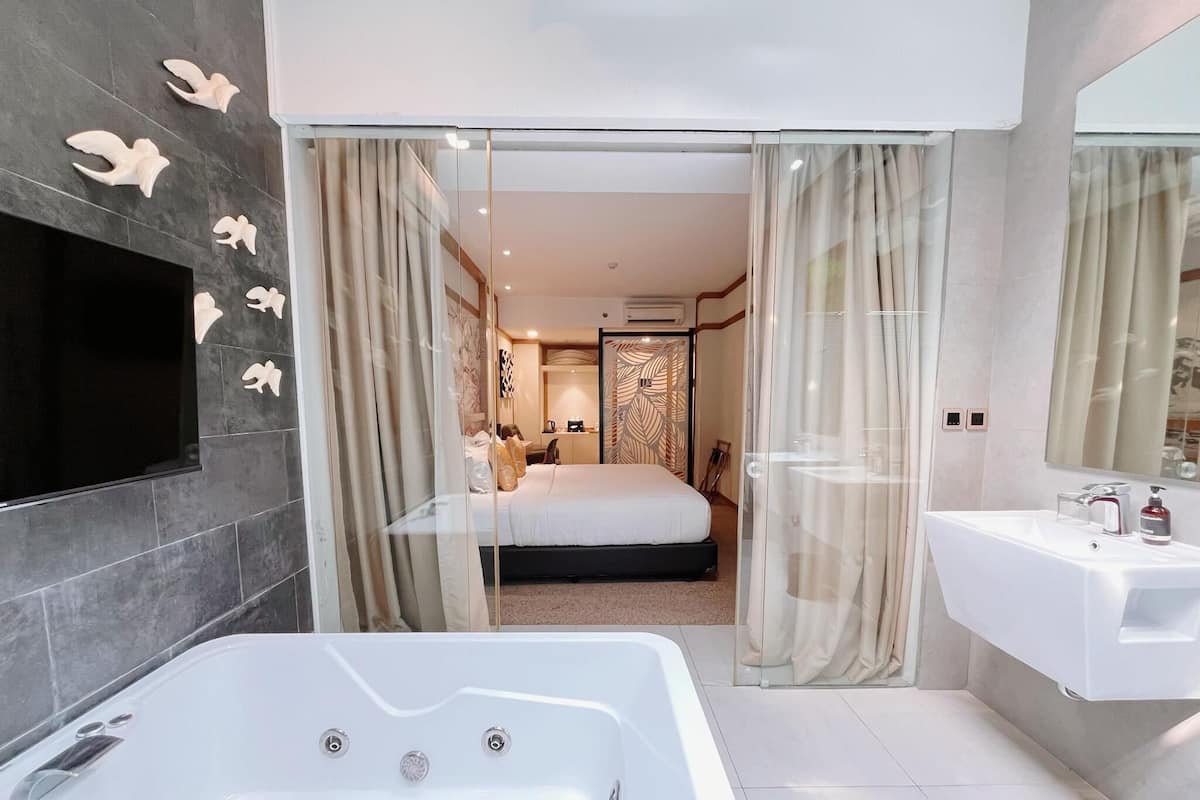 A modern bathroom with a large bathtub, a vanity with a mirror, and a shower area.