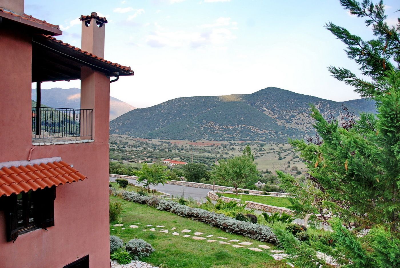 Un edificio con balcón que da a un paisaje montañoso.