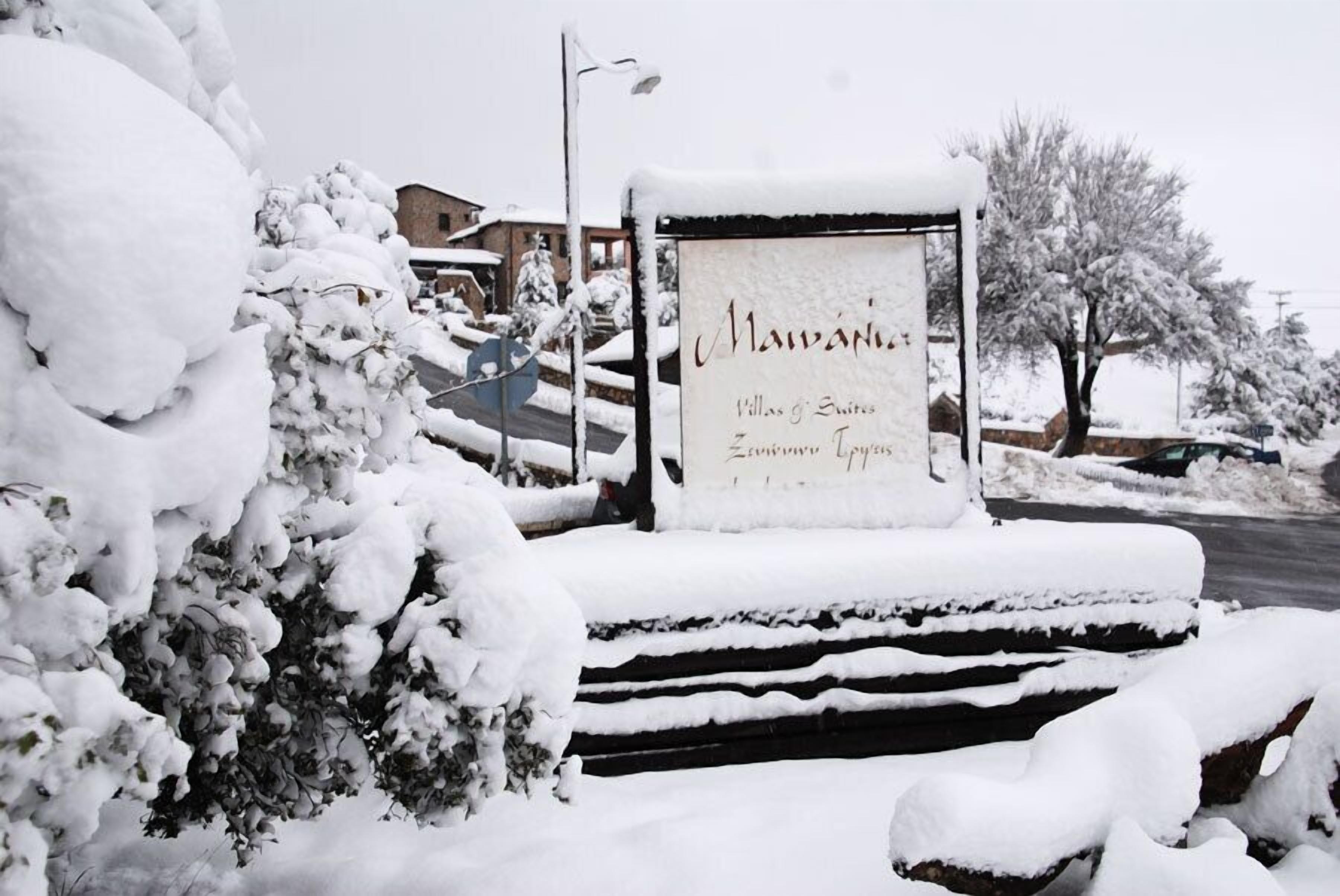 Ein verschneiter Schild mit dem Text 'Mavani Villas & Suites' und 'Zivania Luxury Villas'.