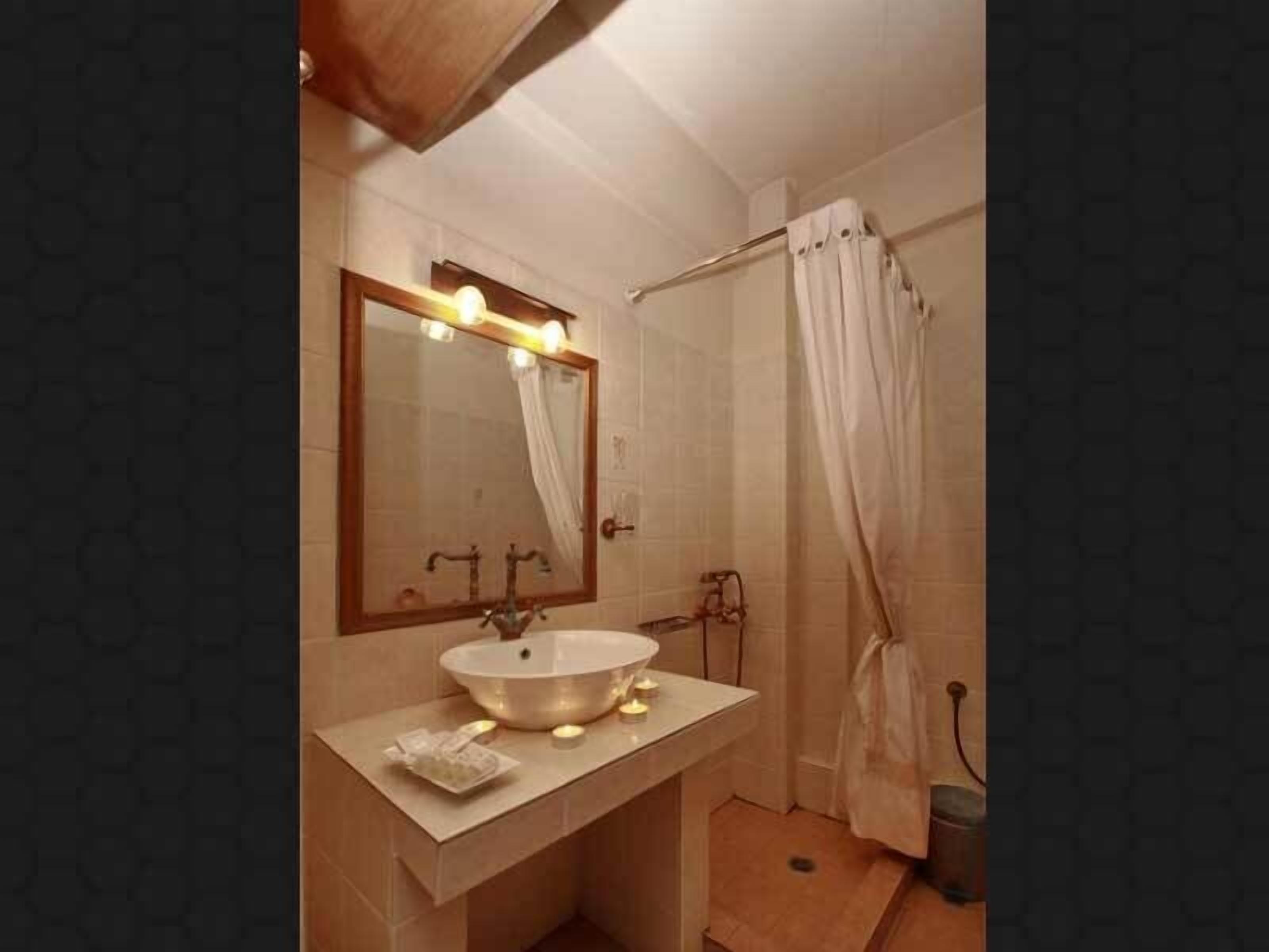 Un baño con un espejo grande, un lavabo y una cortina de ducha.