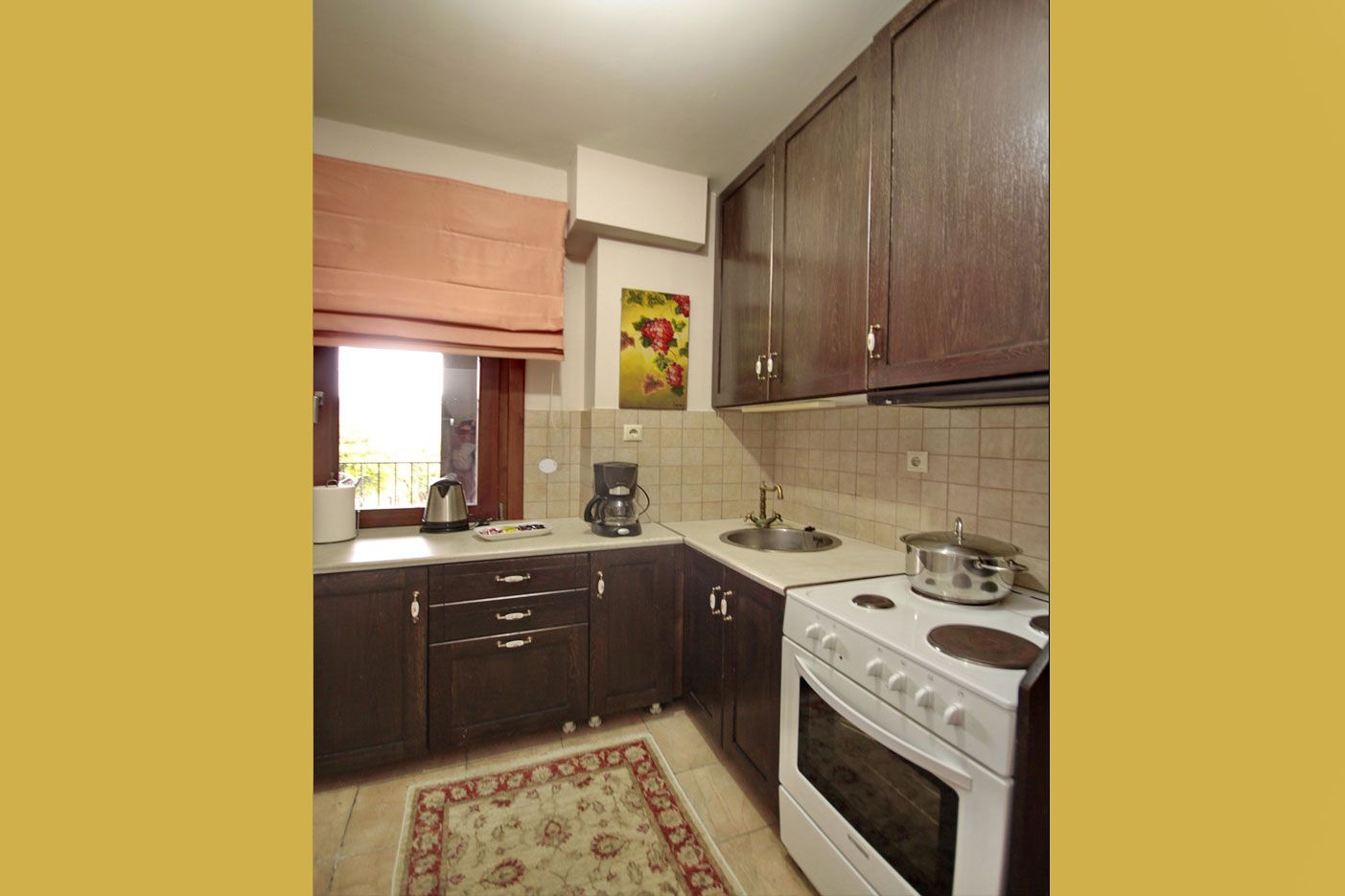 Una cocina con armarios de madera oscura, una estufa blanca y un salpicadero de azulejos.