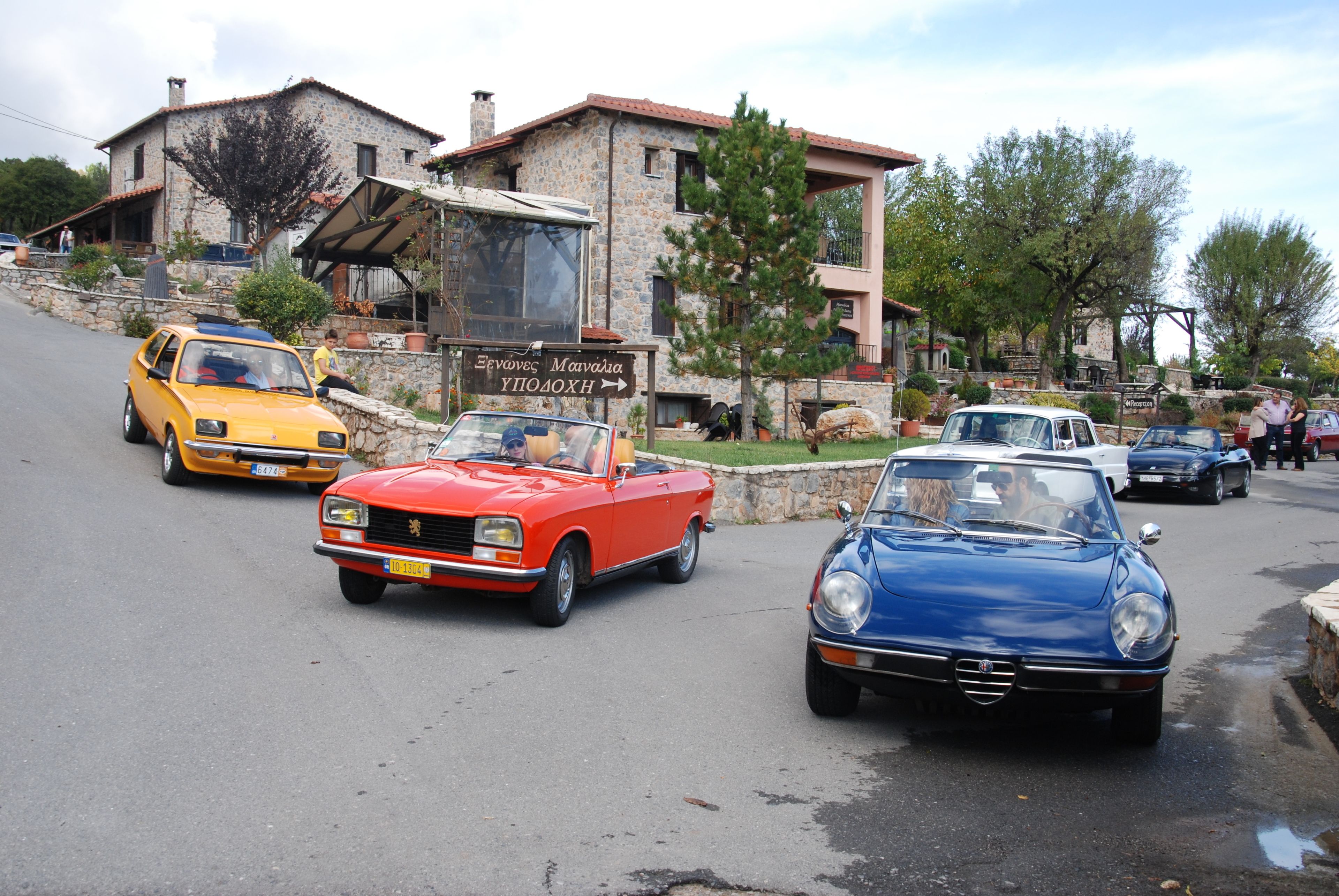 A street with vintage cars parked along the side.