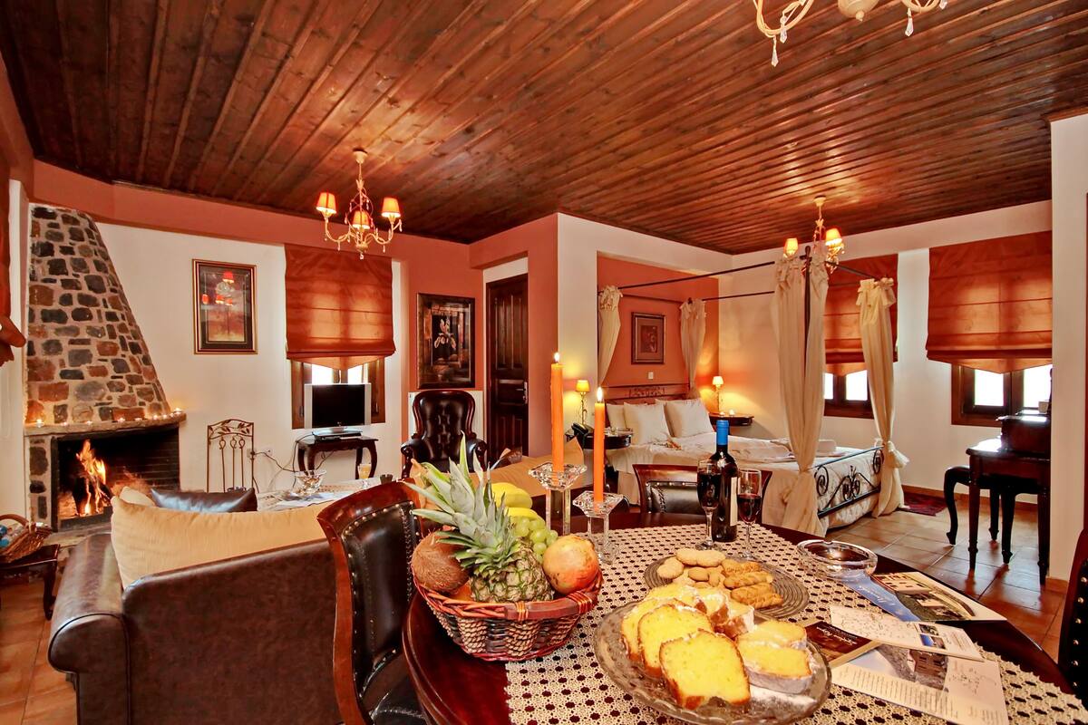 A cozy living room with a fireplace, wooden ceiling, and comfortable seating.