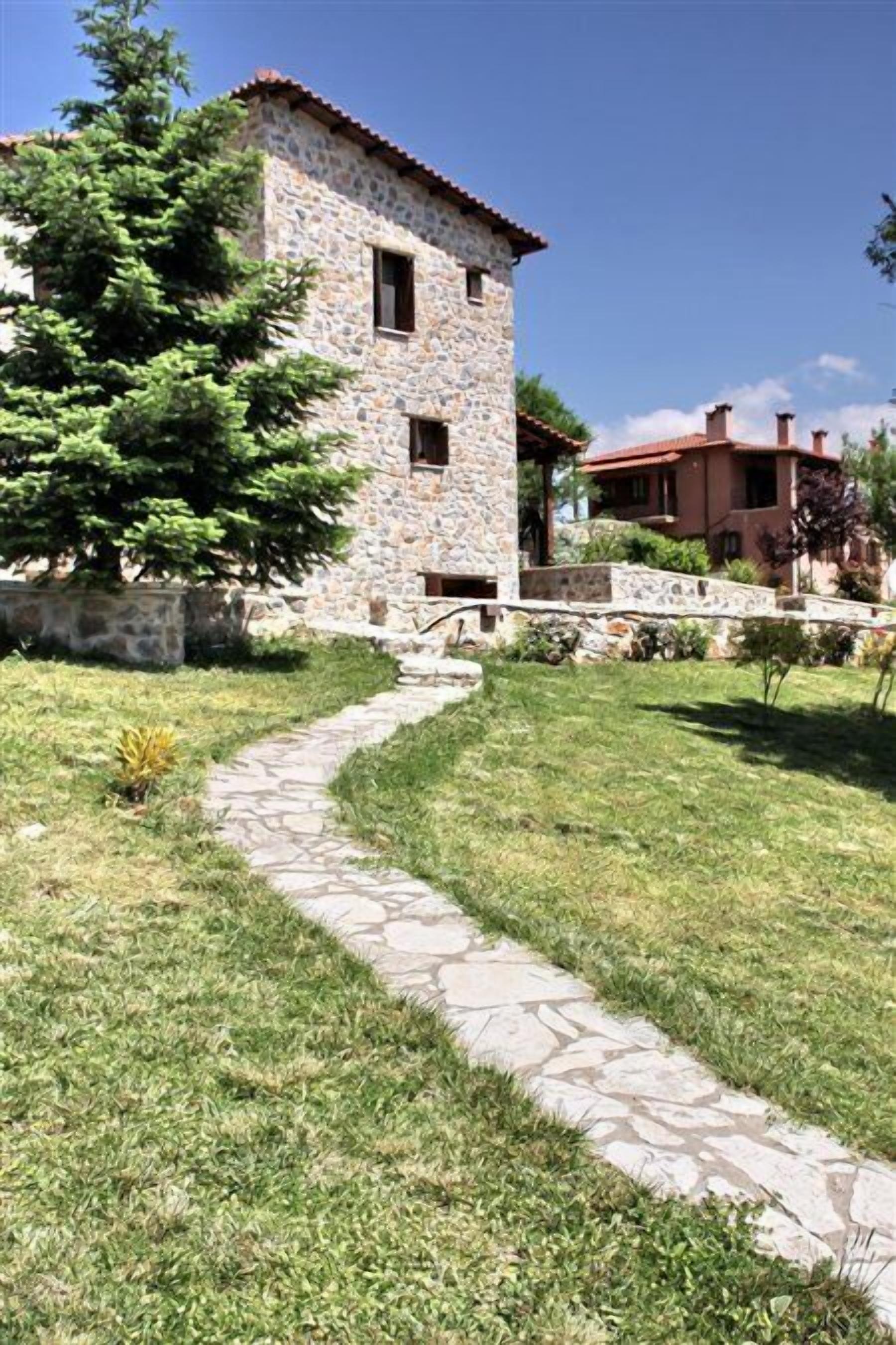 A stone building with a stone pathway leading to a door.