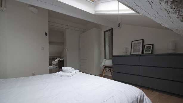 Quarto com cama, cômoda, cadeira e closet espaçoso.