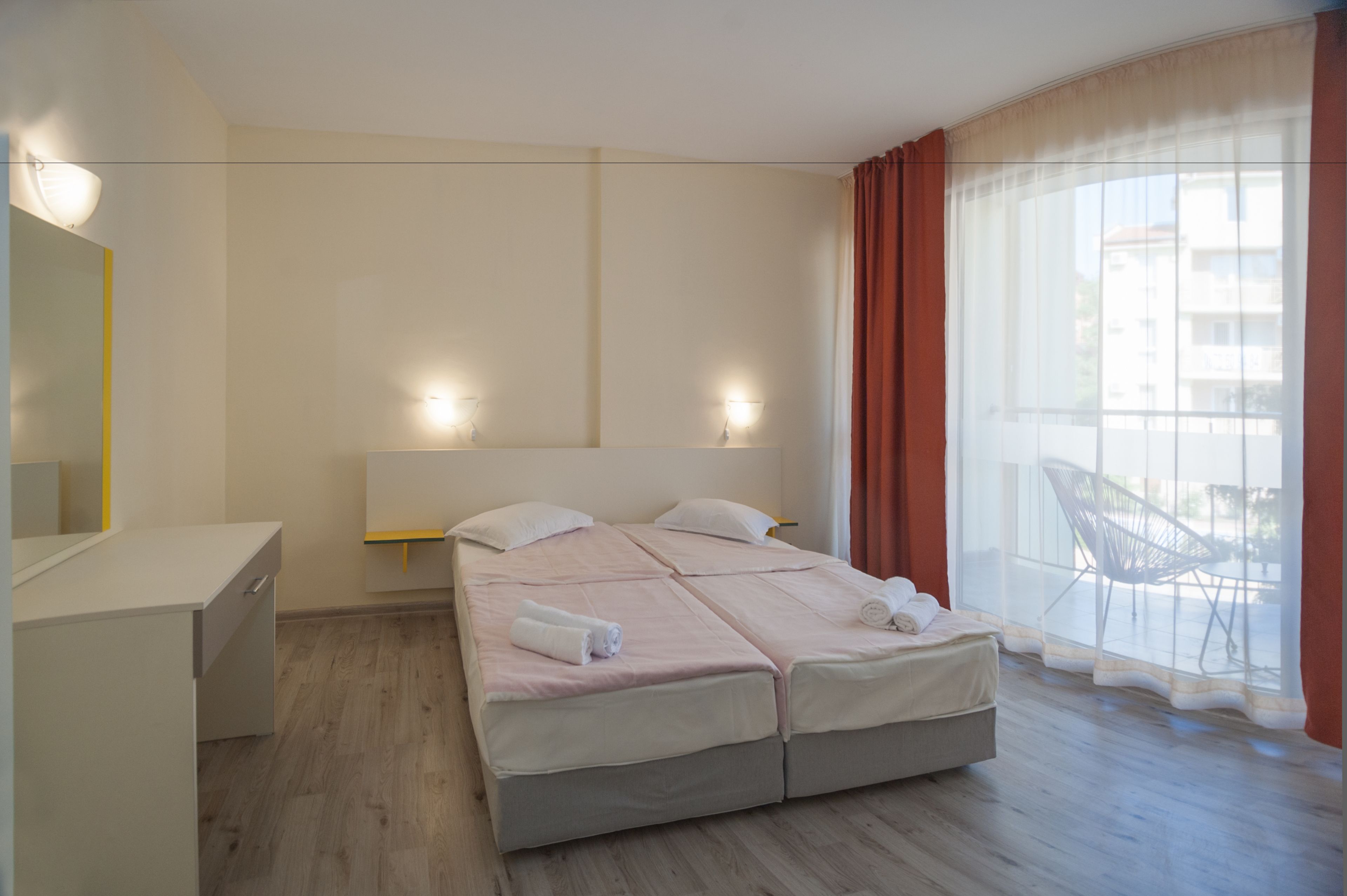 A hotel room with a bed, a desk, and a chair.