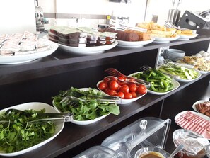 A buffet with various food items including salads, vegetables, and meats.